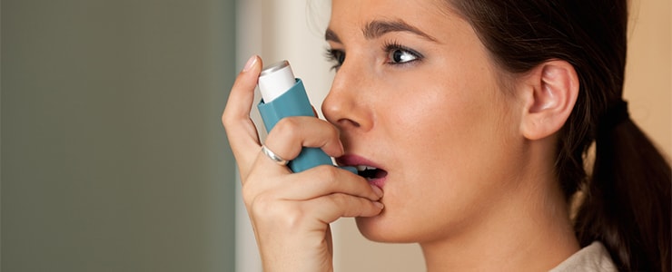 women using asthma inhaler